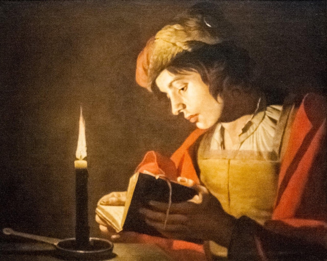 Matthias Stom - A Young Man Reading at Candlelight